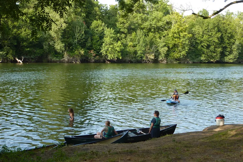 Berge du Cher, deux canoës amarrés dans l’herbe, une personne dans l’eau.